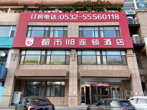 a building with cars parked in front of it at 都市118酒店广电大厦店 in Qingdao