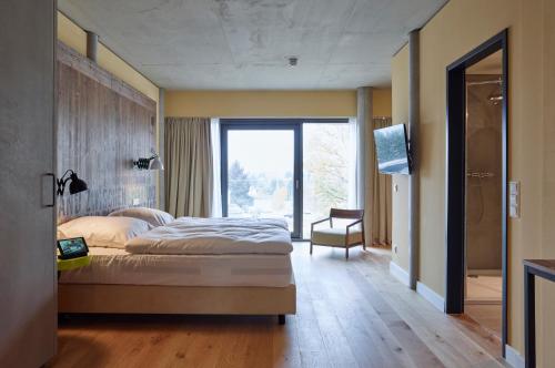a bedroom with a large bed and a large window at Hotel FREIgeist Einbeck BW Signature Collection in Einbeck