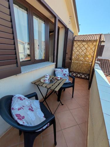 ein Balkon mit zwei Stühlen und einem Tisch auf einem Balkon in der Unterkunft Mare e Monti - Bilocale indipendente in Tortolì