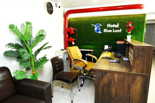 an office with a desk with a blue lizard sign on the wall at Hotel Blue Leaf in Rajkot