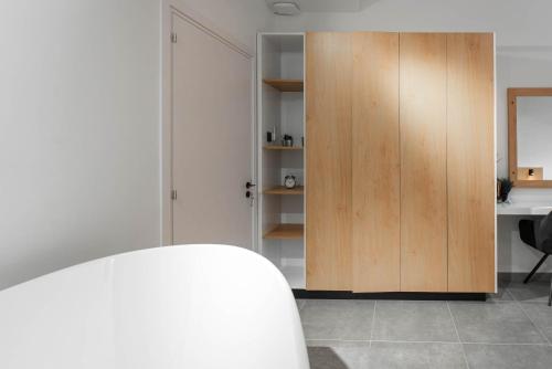 a room with a wooden cabinet and a desk at Kition Urban Suite 1 in Larnaka