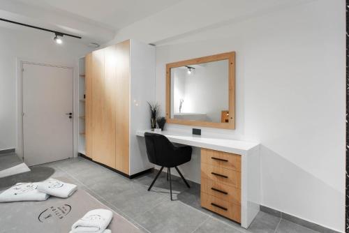 a bathroom with a desk with a mirror and a chair at Kition Urban Suite 1 in Larnaka