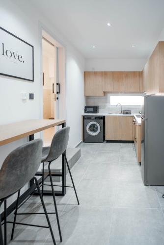 a kitchen with a table and chairs and a refrigerator at Kition Urban Suite 1 in Larnaka