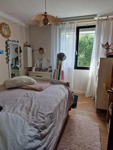 Un dormitorio con una cama y una ventana. en Maison a 10 min de la plage, en Ploemeur