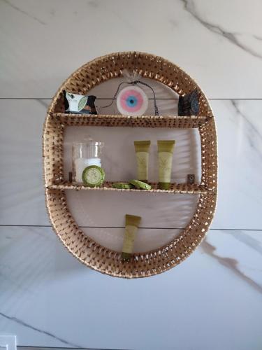 a wicker shelf with items on it on a wall at Little Dream House in Valanidorachi
