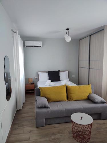 a living room with a couch with yellow pillows at Little Dream House in Valanidorachi