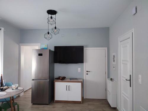 a kitchen with a stainless steel refrigerator and a table at Little Dream House in Valanidorachi