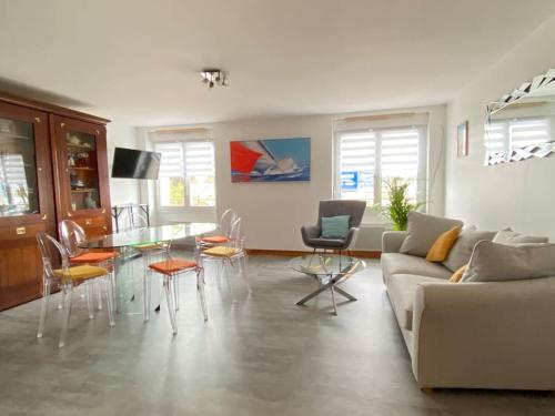 un salon avec un canapé, une table et des chaises dans l'établissement Le Belvédère duplex face port de plaisance, à Étaples