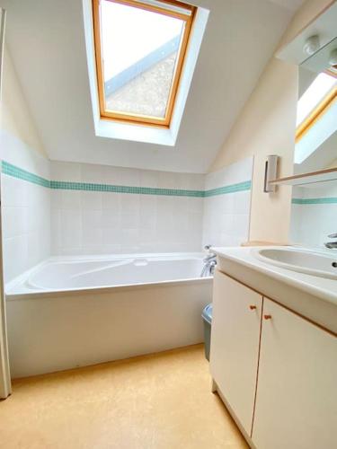 une salle de bain avec une baignoire, un lavabo et une fenêtre dans l'établissement Le Belvédère duplex face port de plaisance, à Étaples