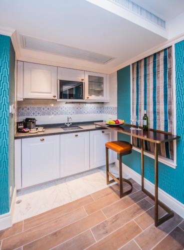 a kitchen with white cabinets and a wooden table at Hotel Madera Hollywood in Hong Kong