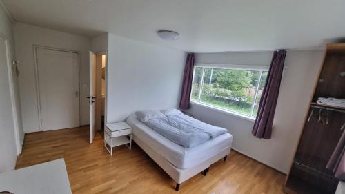 a bedroom with a bed and a window at Igdlo Guesthouse in Reykjavík