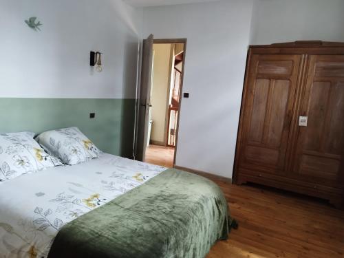 a bedroom with a bed and a wooden door at La grange ô merles in Arrien