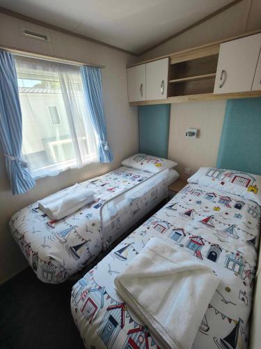 two twin beds in a room with a window at Premium Holiday Home in The New Forest at Hoburne Bashley - Leisure Passes Available to Purchase in New Milton
