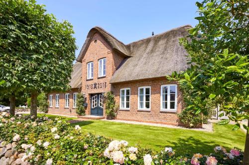 a large brick house with a thatched roof at Rungholt in Oevenum