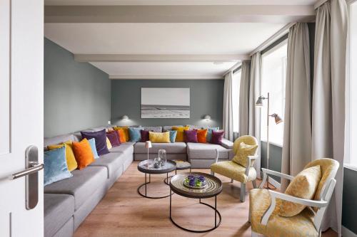 a living room with a couch with colorful pillows at Rungholt in Oevenum