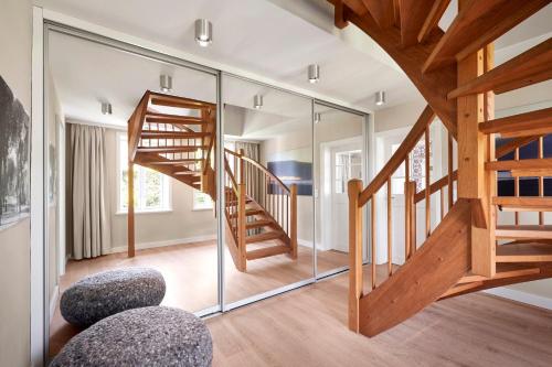 a room with a wooden staircase and a glass wall at Rungholt in Oevenum