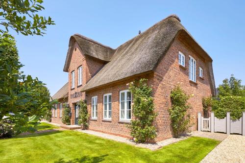 a large brick house with a thatched roof at Rungholt in Oevenum