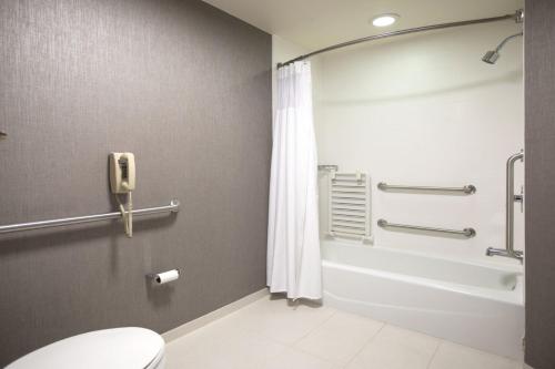 a bathroom with a shower and a toilet and a phone at SpringHill Suites Savannah Airport in Savannah