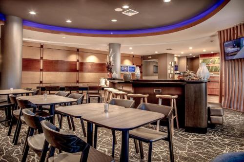 a restaurant with tables and chairs and a bar at SpringHill Suites Savannah Airport in Savannah