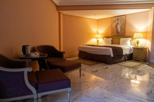 a hotel room with a bed and chairs at Regency Tunis Hotel in Gammarth
