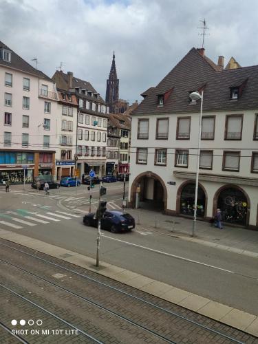 une rue urbaine avec des bâtiments et une voiture sur la route dans l'établissement Murat appartement 3 pieces, à Strasbourg