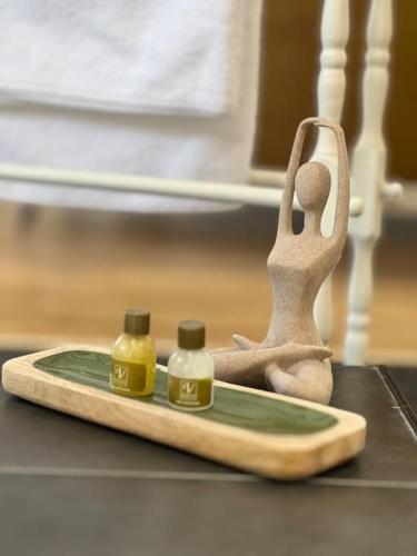 une petite statue d'une personne avec trois bouteilles sur une table dans l'établissement La Suite - Villa Valmy - Hypercentre - Gare SNCF, à Montluçon