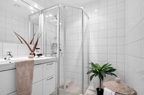 a white bathroom with a shower and a sink at Lervigbrygga 178b in Stavanger