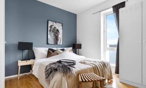 a bedroom with a bed with a blue wall at Lervigbrygga 178b in Stavanger