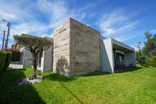 a house with a stone wall and a yard at House on the Top Guimarães in Guimarães