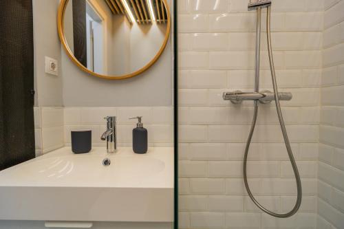 ein Badezimmer mit Waschbecken und Dusche mit Spiegel in der Unterkunft Boutique Luxury Apartment - Alhambra in Bukarest