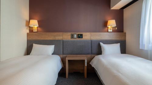 two beds sitting next to each other in a room at Hotel Global View Tsu in Tsu