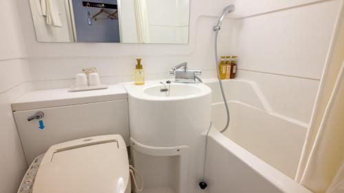 a small bathroom with a toilet and a sink at Hotel Global View Tsu in Tsu