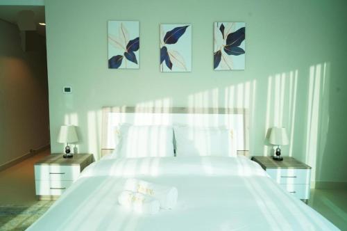 Diamond 2BR Luxurious Retreat in Al Reem في أبوظبي: غرفة نوم بسرير ابيض كبير مع مواقف ليلتين