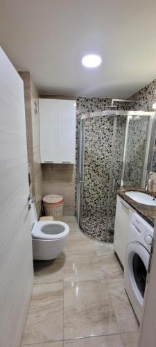 a bathroom with a toilet and a sink and a washing machine at Heart of Skopje Luxury Apartment in Skopje