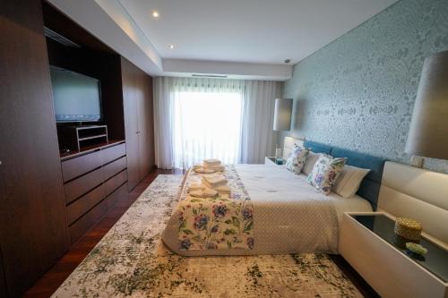 a hotel room with a bed and a television at House on the Top Guimarães in Guimarães