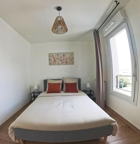 une chambre avec un grand lit avec deux oreillers rouges dans l'établissement Logement cosy près des sites JO, à Stains