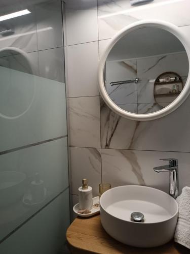 a bathroom with a white sink and a mirror at Little Dream House in Valanidorachi