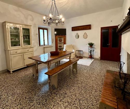 a living room with a wooden table and a chandelier at Podere Casa Rossa a Pienza in Pienza