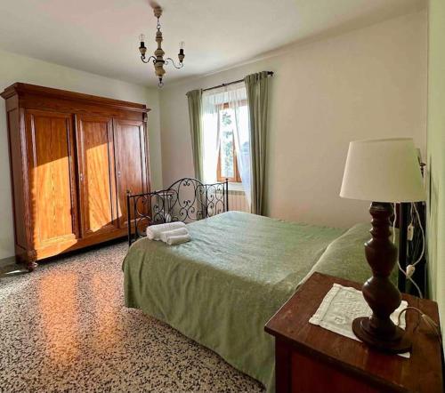 a bedroom with a bed and a table with a lamp at Podere Casa Rossa a Pienza in Pienza