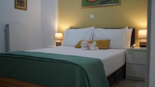 a white bed with a stuffed animal sitting on it at Electra in Saronida