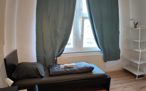 a couch sitting in front of a window with curtains at Charmante Altbauwohnung im Herzen der Stadt Solingen 4 Personen in Solingen