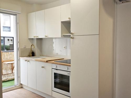  La cuisine est équipée de placards blancs et d'un réfrigérateur. dans l'établissement La plage à 80m, refait à neuf, à Marseille