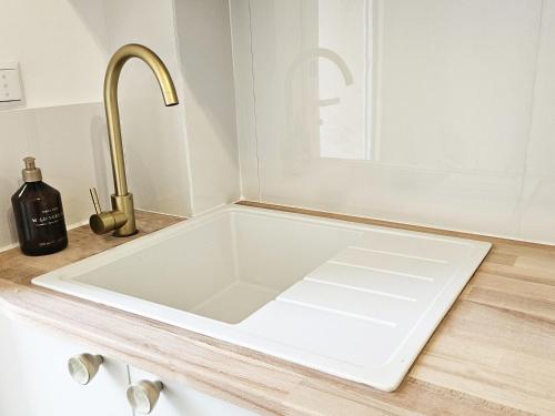 - un évier blanc dans la cuisine avec un robinet dans l'établissement La plage à 80m, refait à neuf, à Marseille