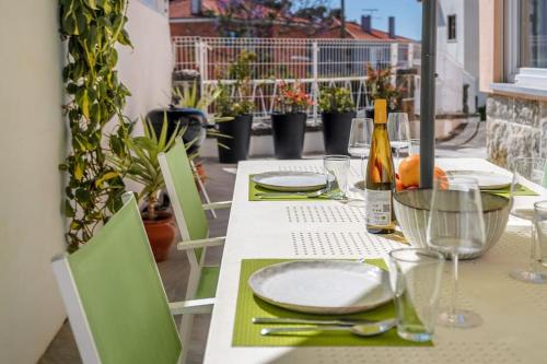 a table with plates and glasses and a bottle of wine at Villa Miramar - Seaside Cascais in Cascais