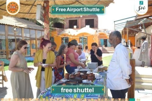 a group of people standing around a table at a free buffet at Fenti Nubian Resort in Aswan
