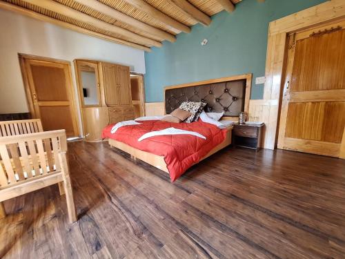 a bedroom with a bed and a wooden floor at Green Villa Guest House Ladakh by LexStays in Leh