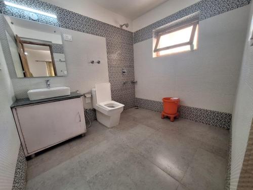 a bathroom with a toilet and a sink and a mirror at Green Villa Guest House Ladakh by LexStays in Leh