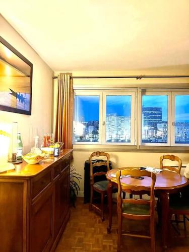 une cuisine avec une table, des chaises et des fenêtres dans l'établissement The Cosy Eiffel, à Paris