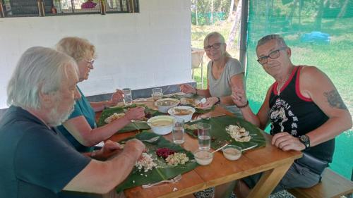 a group of people sitting around a table eating food at Prakruthi Residency Munroeisland in Munroe Island
