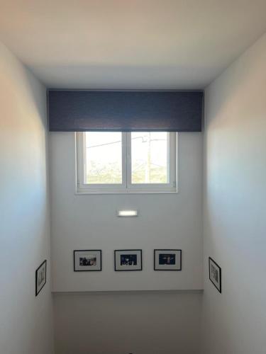 a white room with a window and pictures on the wall at Casa do Preto in Pitões das Júnias